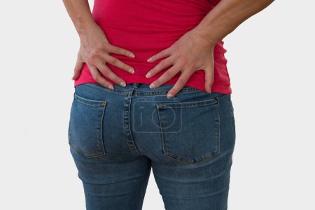Foto de Mujer que sufre de dolor de espalda, dolor de espalda baja sobre fondo blanco. - Imagen libre de derechos