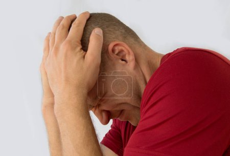 Foto de Hombre aislado sobre fondo blanco sufriendo de dolor de cabeza severo. - Imagen libre de derechos