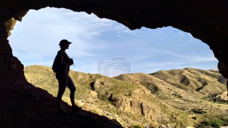 Foto de Silueta de enfoque suave de la mujer en una cueva en viaje en la naturaleza. Imagen borrosa con una silueta de una mujer en el borde de una cueva en un viaje por la naturaleza. - Imagen libre de derechos