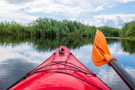Téléchargez les photos : Point de vue Kayaker. Arc de kayak rouge avec vue sur la rivière et se précipite. Concept de kayak de rivière. Vacances actives dans la nature sauvage. - en image libre de droit