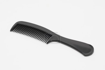A black plastic comb on a white background. Isolated.