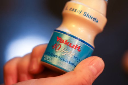 Téléchargez les photos : Fermer le récipient à main avec une boisson au lait probiotique Yakult - en image libre de droit