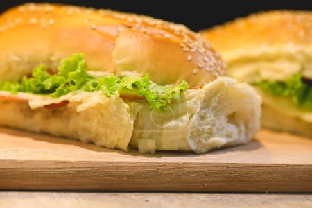 Foto de Sandwiches de pan con semillas de sésamo, pechuga de pavo, queso mozzarella, lechuga, tomates y mayonesa sazonada - Imagen libre de derechos
