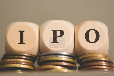 Téléchargez les photos : L'acronyme IPO écrit sur des cubes de bois et des pièces de monnaie sur fond gris. Studio photo. - en image libre de droit