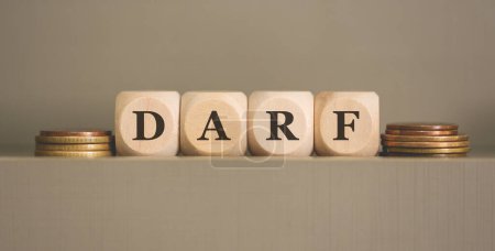 Téléchargez les photos : L'acronyme DARF écrit sur des cubes de bois et des pièces de monnaie sur fond gris. Studio photo. - en image libre de droit