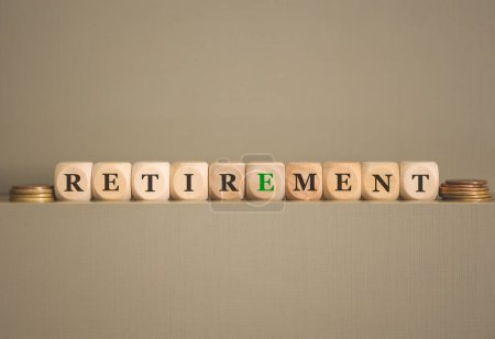 Photo for The word RETIREMENT written on wooden cubes and coins on grey background. Studio photo. - Royalty Free Image