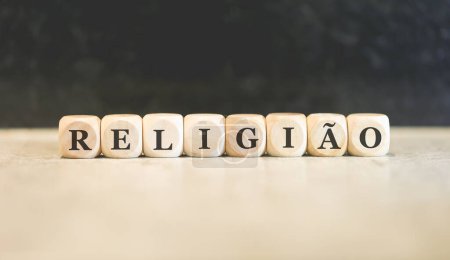 Photo for The word RELIGION in Brazilian Portuguese written on wooden cubes. Black background. - Royalty Free Image