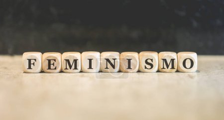 Photo for The word FEMINISM in Brazilian Portuguese written on wooden cubes. Black background. - Royalty Free Image