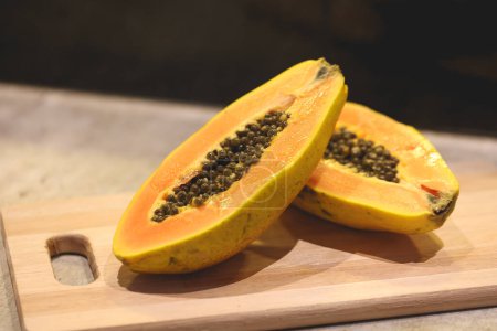 Téléchargez les photos : Vue rapprochée de la papaye tranchée sur une planche de bois - en image libre de droit