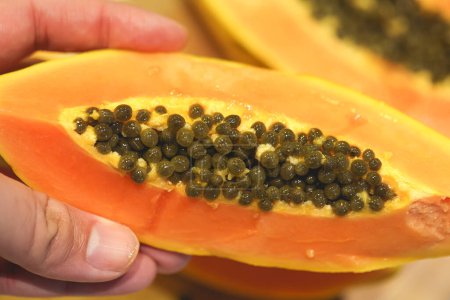 Photo for Close-up view of person holding sliced papaya - Royalty Free Image
