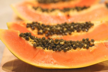 Photo for Close-up view of sliced papaya on wooden board - Royalty Free Image