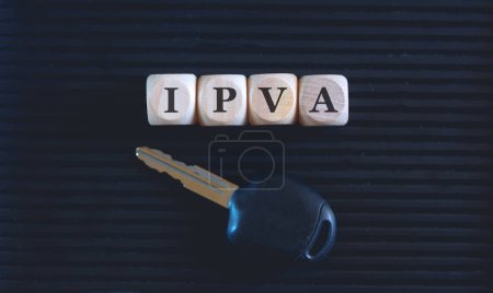 Foto de El acrónimo IPVA escrito sobre cubos de madera y la llave sobre fondo negro. - Imagen libre de derechos