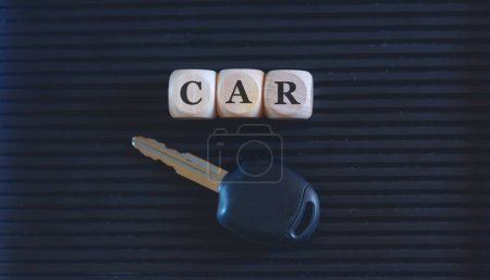 Photo for The word car written on wooden blocks and key on black background. Close up photo. - Royalty Free Image