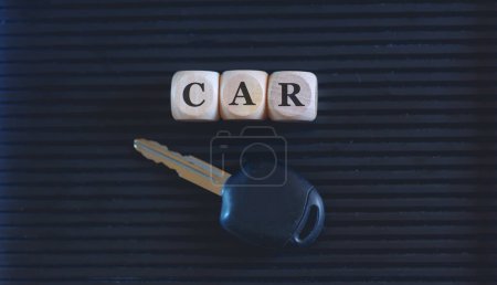 Photo for The word car written on wooden blocks and key on black background. Close up photo. - Royalty Free Image
