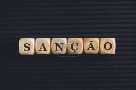 Foto de Inscripción SANCIÓN en portugués brasileño escrita sobre cubos de madera. Fondo negro. - Imagen libre de derechos