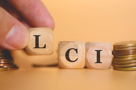 Photo for Close-up view of man forming acronym LCI written on wooden cubes. Studio photo. - Royalty Free Image
