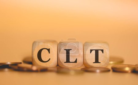 Photo for Acronym CLT written on wooden cubes and piles of coins. Studio photo. - Royalty Free Image