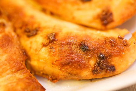 Téléchargez les photos : Filet de poitrine de poulet grillé sur une assiette blanche en gros plan photo. - en image libre de droit