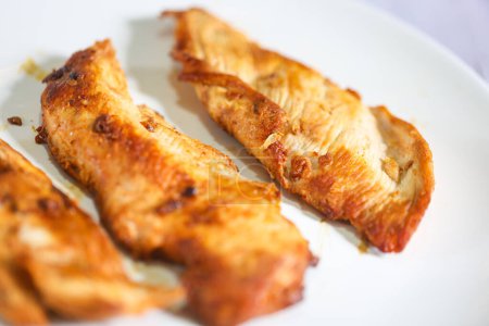 Téléchargez les photos : Filet de poitrine de poulet grillé sur une assiette blanche en gros plan photo. - en image libre de droit