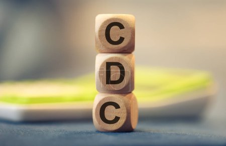 Téléchargez les photos : L'acronyme CDC écrit sur des cubes de bois. Une calculatrice dans la composition. - en image libre de droit