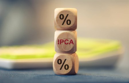 Téléchargez les photos : L'acronyme IPCA pour Broad National Consumer Price Index écrit sur des cubes de bois. Une calculatrice dans la composition. - en image libre de droit