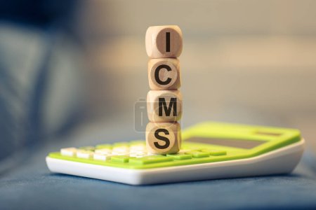 Photo for The acronym ICMS written on wooden cubes. A calculator in the composition. - Royalty Free Image