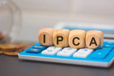 Téléchargez les photos : L'acronyme IPCA écrit sur des cubes de bois. Une calculatrice dans la composition. - en image libre de droit