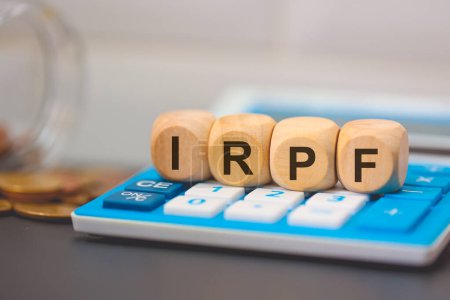 The acronym IRPF written on wooden cubes. A calculator in the composition. 