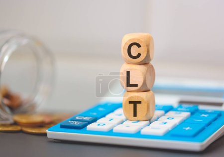 Téléchargez les photos : L'acronyme CLT écrit sur des cubes de bois. Une calculatrice dans la composition. - en image libre de droit