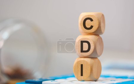 The acronym CDI written on wooden cubes. A calculator in the composition. 