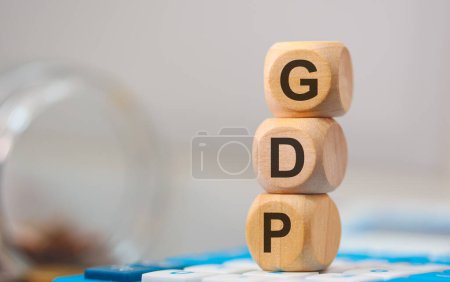 Téléchargez les photos : L'acronyme GDP écrit sur des cubes de bois. Une calculatrice dans la composition. - en image libre de droit