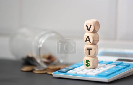 Foto de El acrónimo IVA escrito en cubos de madera. Una calculadora en la composición. - Imagen libre de derechos