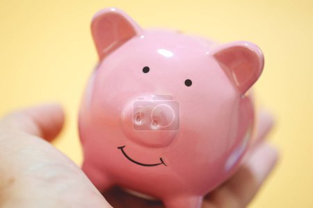 Photo for Close-up view of person holding pink piggy bank. Finance concept. - Royalty Free Image