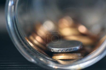 Foto de Dinero de Brasil. Monedas brasileñas dentro de un frasco de vidrio. Economía brasileña. Macro fotografía. - Imagen libre de derechos