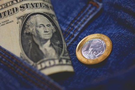Foto de Moneda real y billetes de dólar de los Estados Unidos en un bolsillo vaquero en macro foto. - Imagen libre de derechos