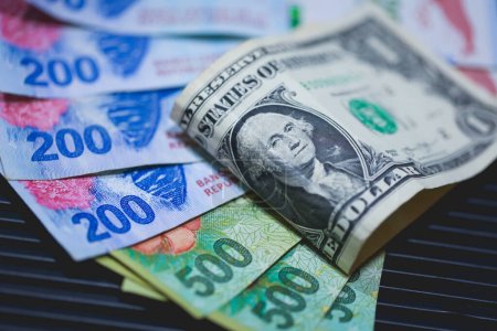 Foto de Billetes de peso argentino y billetes de dólar de Estados Unidos. Economía y finanzas. - Imagen libre de derechos
