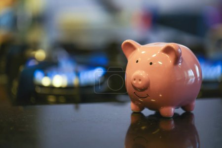 Photo for Cute piggy bank on gas stove close-up view - Royalty Free Image
