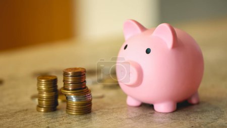 Photo for Pink piggy bank and stacks of coins, close-up view - Royalty Free Image