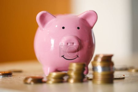 Photo for Pink piggy bank and stacks of coins, close-up view - Royalty Free Image