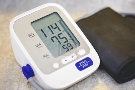 Photo for Electronic blood pressure monitor on wooden table background - Royalty Free Image
