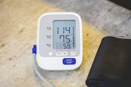 Photo for Electronic blood pressure monitor on wooden table background - Royalty Free Image