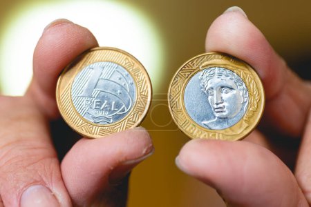 Photo for Man holding a Brazilian coins in his hands in macro photography. - Royalty Free Image