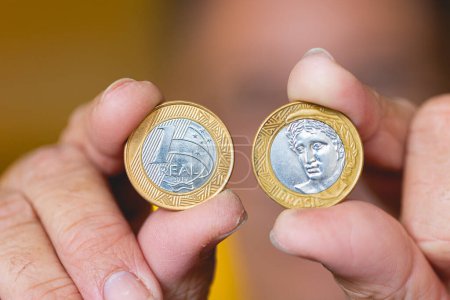 Photo for Man holding a Brazilian coins in his hands in macro photography. - Royalty Free Image