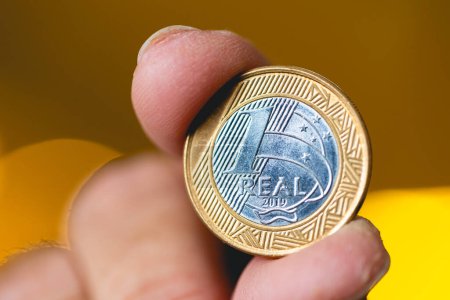 Photo for Man holding a Brazilian coin in his hand in macro photography. - Royalty Free Image