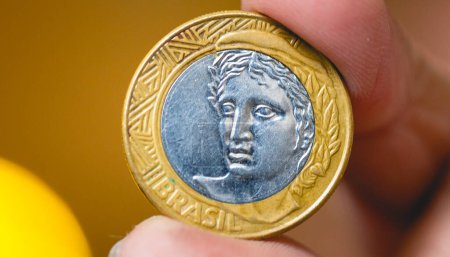Photo for Man holding a Brazilian coin in his hand in macro photography. - Royalty Free Image