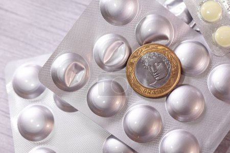 Foto de Una moneda real en el paquete de blister píldoras de plata, mdecine y dinero concepto de fondo - Imagen libre de derechos