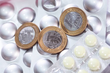 Foto de Monedas reales en las píldoras de plata blister pack, medicina y dinero concepto fondo - Imagen libre de derechos
