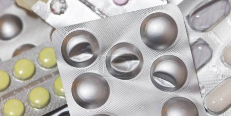 Close-up view of tablets pills heap in a blister packaging, medicine and healthcare concept bakcgorund 