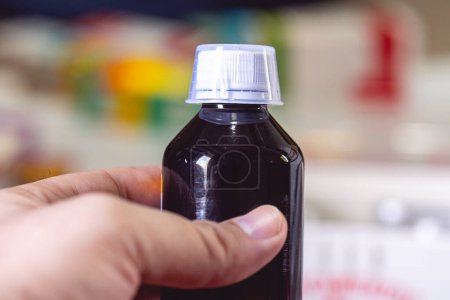 Téléchargez les photos : Vue rapprochée d'une bouteille médicale en plastique sombre avec couvercle blanc - en image libre de droit