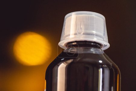 Foto de Vista de cerca de la botella médica de plástico oscuro con una tapa blanca - Imagen libre de derechos